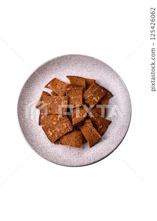Crispy homemade brown bread chips with seeds and grains, salt, spices 125426062