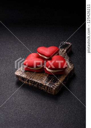Red macaroons in the shape of a heart, sweets for the holiday of Valentine's Day Red macaroons in the shape of a heart, sweets for the holiday of Valentine's Day 125426211