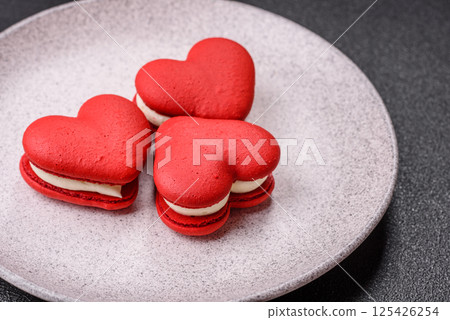 Red macaroons in the shape of a heart, sweets for the holiday of Valentine's Day Red macaroons in the shape of a heart, sweets for the holiday of Valentine's Day 125426254