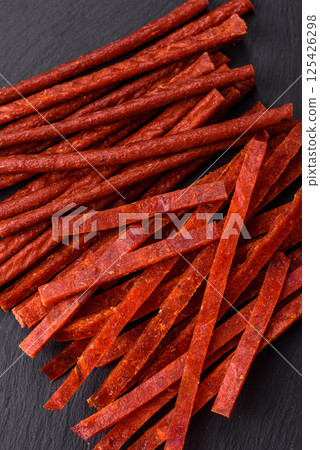 Jerky dried fish sticks with salt and spices 125426298