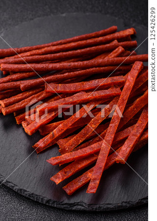 Jerky dried fish sticks with salt and spices 125426299