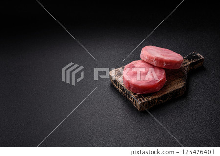 Two fresh slices of raw tuna fillet with spices and herbs 125426401
