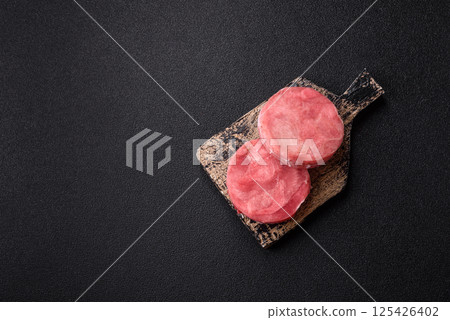 Two fresh slices of raw tuna fillet with spices and herbs 125426402