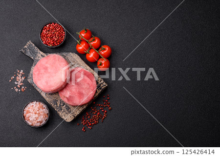 Two fresh slices of raw tuna fillet with spices and herbs Two fresh slices of raw tuna fillet with spices and herbs 125426414