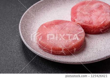 Two fresh slices of raw tuna fillet with spices and herbs 125426421