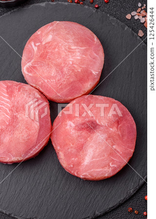 Two fresh slices of raw tuna fillet with spices and herbs 125426444