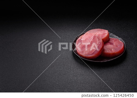 Two fresh slices of raw tuna fillet with spices and herbs Two fresh slices of raw tuna fillet with spices and herbs 125426450