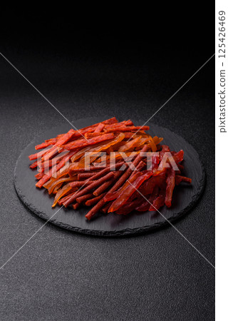 Jerky, dried fish in the form of sticks with salt, spices and herbs 125426469