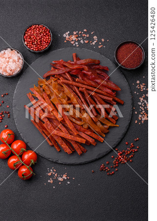 Jerky, dried fish in the form of sticks with salt, spices and herbs 125426480