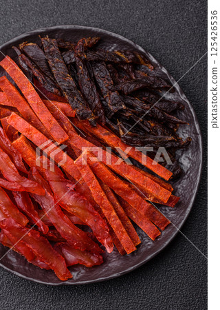 Jerky, dried fish in the form of sticks with salt, spices and herbs 125426536