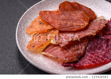 Jerky, dried meat in the form of slices with salt, spices and herbs 125426561