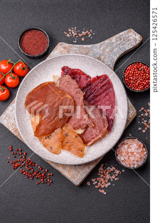 Jerky, dried meat in the form of slices with salt, spices and herbs 125426571
