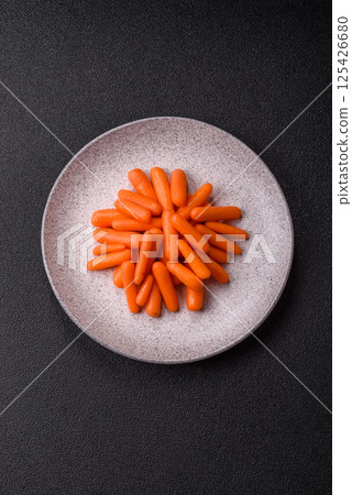 Raw peeled mini baby carrots as an ingredient for preparing a vegetarian food Raw peeled mini baby carrots as an ingredient for preparing a vegetarian food 125426680