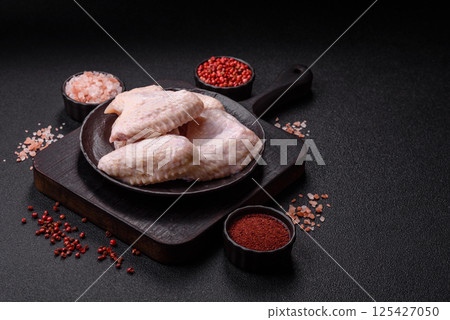 Raw chicken wings with salt, spices and herbs Raw chicken wings with salt, spices and herbs 125427050