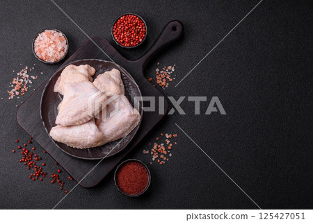 Raw chicken wings with salt, spices and herbs Raw chicken wings with salt, spices and herbs 125427051