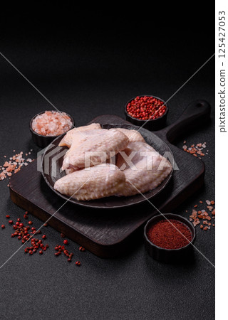 Raw chicken wings with salt, spices and herbs Raw chicken wings with salt, spices and herbs 125427053