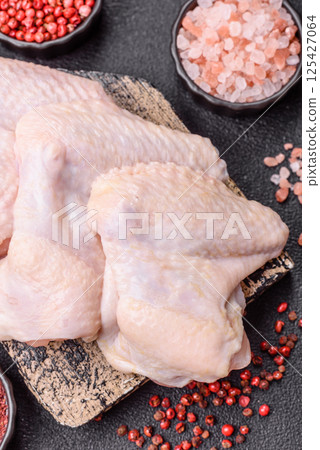Raw chicken wings with salt, spices and herbs Raw chicken wings with salt, spices and herbs 125427064