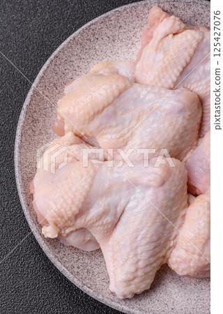 Raw chicken wings with salt, spices and herbs Raw chicken wings with salt, spices and herbs 125427076