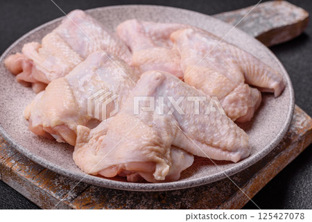 Raw chicken wings with salt, spices and herbs Raw chicken wings with salt, spices and herbs 125427078