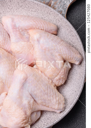 Raw chicken wings with salt, spices and herbs 125427080