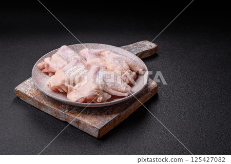 Raw chicken wings with salt, spices and herbs Raw chicken wings with salt, spices and herbs 125427082