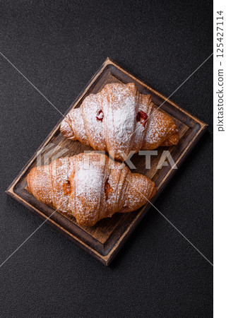 Sweet fresh crispy croissant with fruit filling Sweet fresh crispy croissant with fruit filling 125427114
