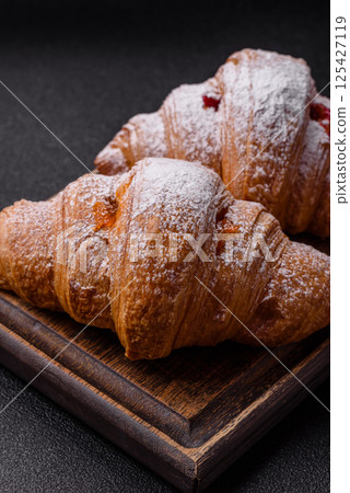 Sweet fresh crispy croissant with fruit filling Sweet fresh crispy croissant with fruit filling 125427119