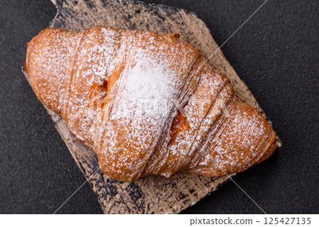 Sweet fresh crispy croissant with fruit filling 125427135