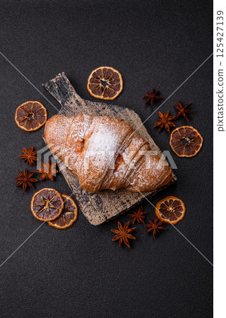 Sweet fresh crispy croissant with fruit filling Sweet fresh crispy croissant with fruit filling 125427139