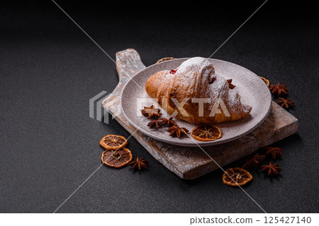 Sweet fresh crispy croissant with fruit filling 125427140