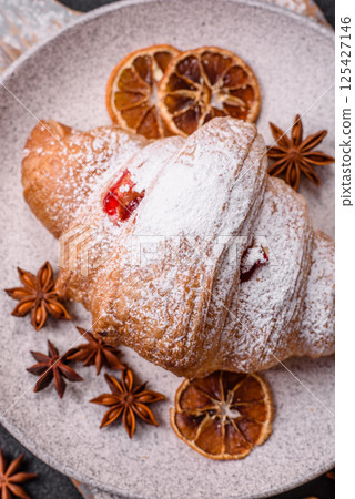 Sweet fresh crispy croissant with fruit filling Sweet fresh crispy croissant with fruit filling 125427146