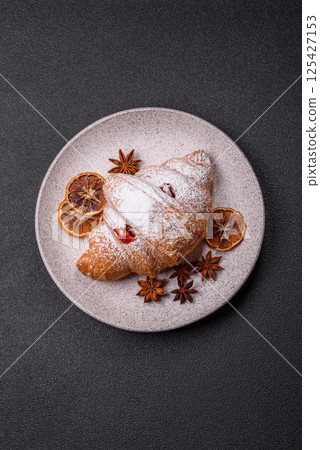 Sweet fresh crispy croissant with fruit filling Sweet fresh crispy croissant with fruit filling 125427153