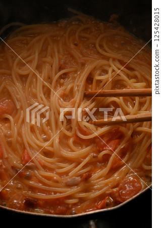 Cooking pasta with tomato sauce Cooking pasta with tomato sauce 125428015