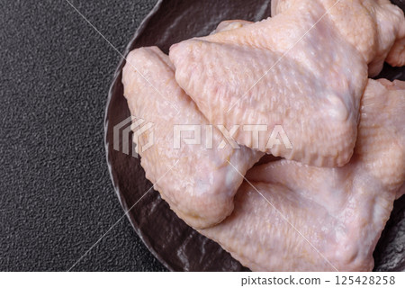 Raw chicken wings with salt, spices and herbs Raw chicken wings with salt, spices and herbs 125428258