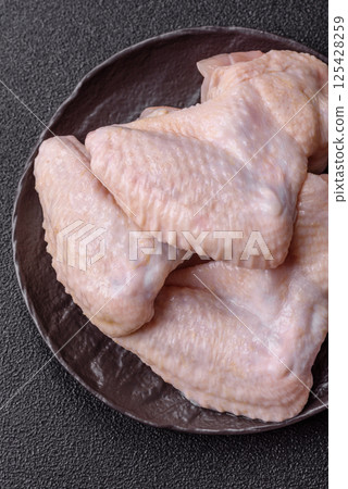 Raw chicken wings with salt, spices and herbs 125428259