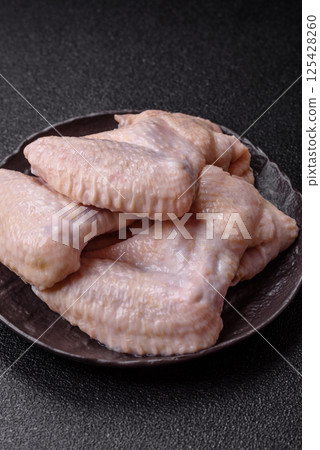 Raw chicken wings with salt, spices and herbs 125428260