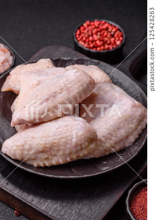 Raw chicken wings with salt, spices and herbs Raw chicken wings with salt, spices and herbs 125428263