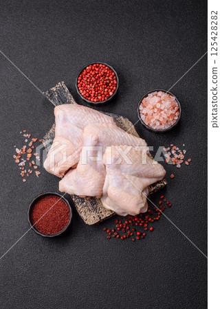 Raw chicken wings with salt, spices and herbs 125428282