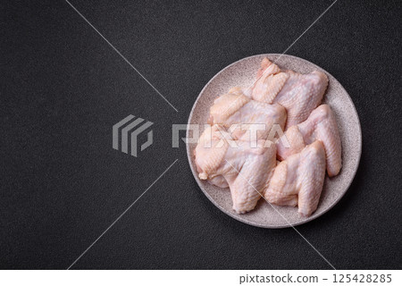 Raw chicken wings with salt, spices and herbs Raw chicken wings with salt, spices and herbs 125428285