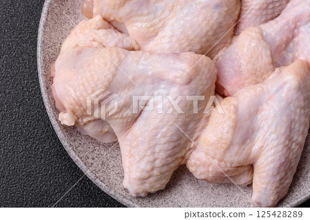 Raw chicken wings with salt, spices and herbs 125428289