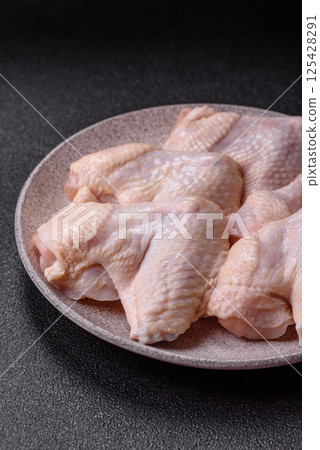 Raw chicken wings with salt, spices and herbs 125428291