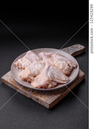Raw chicken wings with salt, spices and herbs Raw chicken wings with salt, spices and herbs 125428299