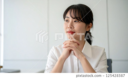 Female businesswoman thinking with hands folded 125428387