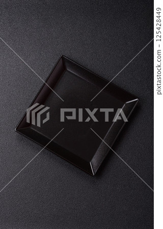 Empty ceramic round plate on dark textured concrete background Empty ceramic round plate on dark textured concrete background 125428449