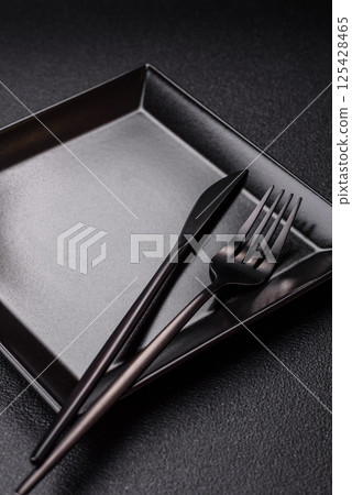 Empty ceramic round plate on dark textured concrete background 125428465