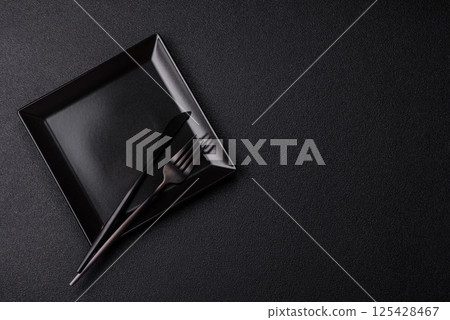 Empty ceramic round plate on dark textured concrete background Empty ceramic round plate on dark textured concrete background 125428467