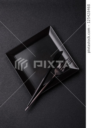 Empty ceramic round plate on dark textured concrete background Empty ceramic round plate on dark textured concrete background 125428468