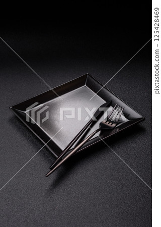 Empty ceramic round plate on dark textured concrete background Empty ceramic round plate on dark textured concrete background 125428469