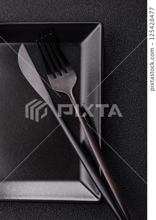 Empty ceramic round plate on dark textured concrete background 125428477