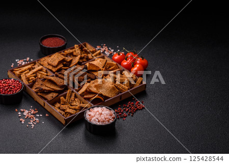 Crispy homemade brown bread chips with seeds and grains Crispy homemade brown bread chips with seeds and grains 125428544